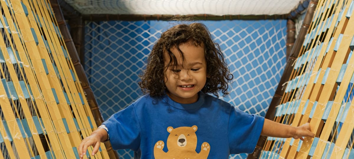 A toddler grinning inside the playhouse.