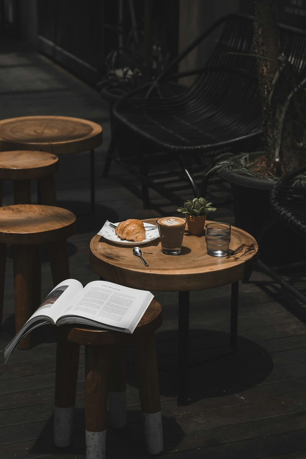A latte and croissant on a wooden table at Fusion café.